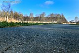 28-01-2023 Breda - In het gedeelte van de Vierde Bergboezem dat men volgens een afgelopen week geplaatst bord 7 maanden gaat afsluiten, zitten verschillende scheuren in het asfalt boven op de dijk. - Fotokrant