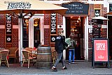 15-03-2020 Breda - Vanwege het Coronavirus heeft de overheid bepaald dat alle horeca moet sluiten. Voorlopig  kan men niet onder Moeke's parasol aan een pint. Na 18:00 ruimt Moeke's Mooiste de kussens op en krijgt daarbij hulp van een kind dat morgen ook niet naar school hoeft. - Fotokrant