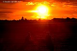 17-08-2020 Breda - In de polder ten noorden van de stad kijken vanuit een weiland twee jonge dames naar de zonsondergang. - Fotokrant