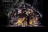25-12-2025 Bavel - Een prachtige mooi verlichtte klassieke kerststal staat in het dorp in een voortuin. - Fotokrant