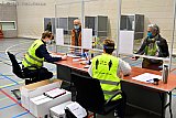 15-03-2021 Breda - Medewerkers van het stembureau zitten in de ruime sporthal achter spatschermen en dragen hesjes met de tekst houd 1,5 meter afstand. - Fotokrant
