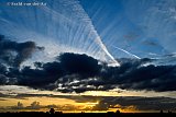 11-10-2021 Breda -  Zonsondergang met een uit elkaar drijvende regenwolk en opmerkelijke strepen in de blauwe lucht te noorden van de stad. - Fotokrant
